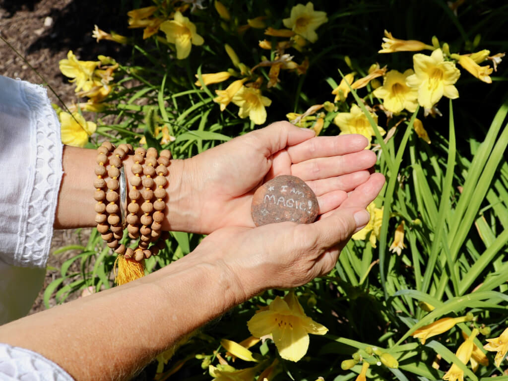 Regan holding rock with I am Magic written on it