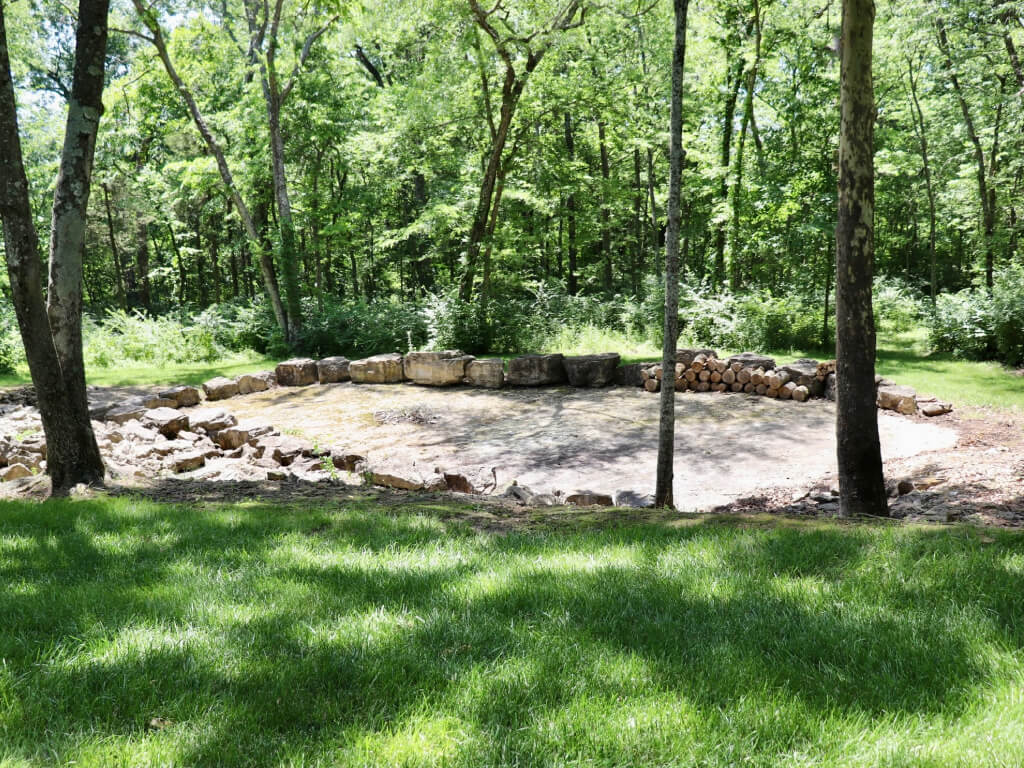 Concrete pad surrounded by boulders in the middle of a forest